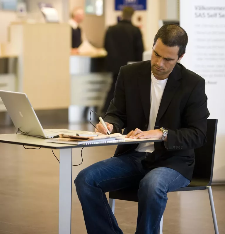 Man sitting at the table and using C-Pen connected to the computer